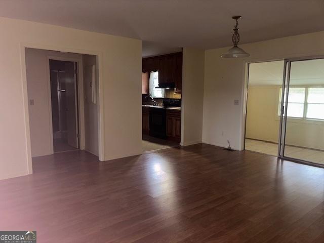 unfurnished living room featuring dark hardwood / wood-style flooring and sink