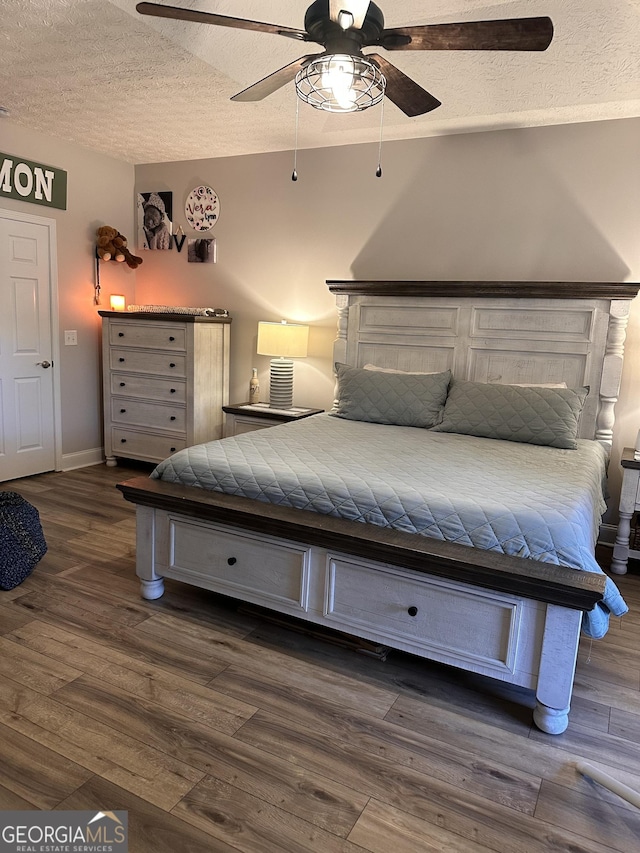 unfurnished bedroom featuring a textured ceiling, ceiling fan, and dark wood-type flooring