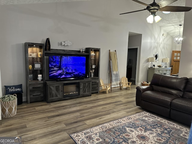 living room with hardwood / wood-style floors and ceiling fan with notable chandelier