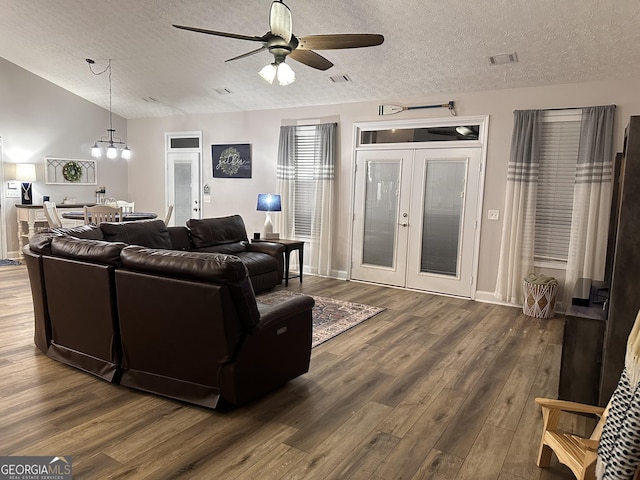 living room with ceiling fan with notable chandelier, french doors, a textured ceiling, and dark hardwood / wood-style floors