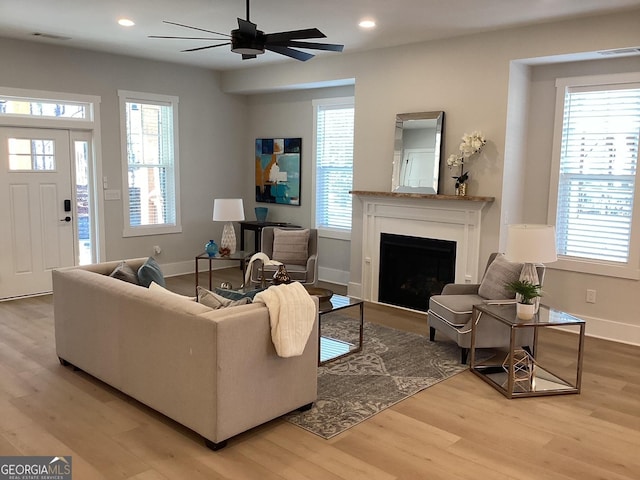 living room featuring light hardwood / wood-style floors and ceiling fan