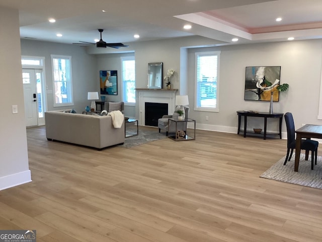 living room featuring a wealth of natural light, light hardwood / wood-style floors, and ceiling fan