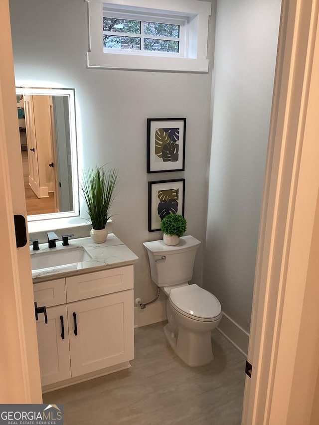 bathroom featuring hardwood / wood-style flooring, vanity, and toilet