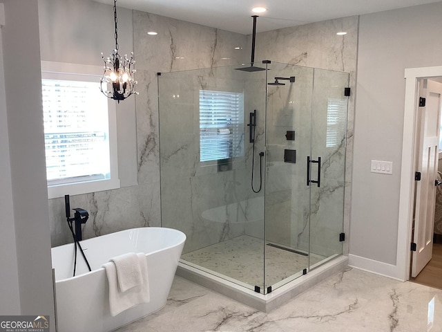 bathroom featuring an inviting chandelier and shower with separate bathtub