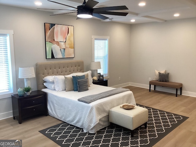 bedroom featuring ceiling fan, wood-type flooring, and multiple windows