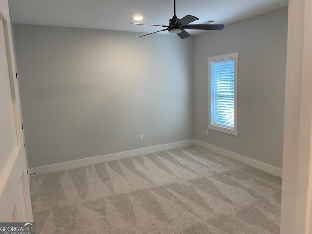 spare room featuring light colored carpet and ceiling fan