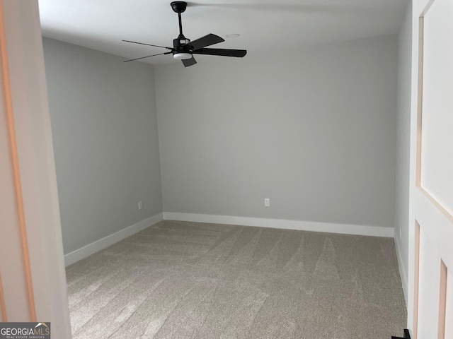 carpeted spare room featuring ceiling fan