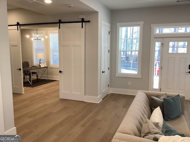 foyer with wood-type flooring and a barn door