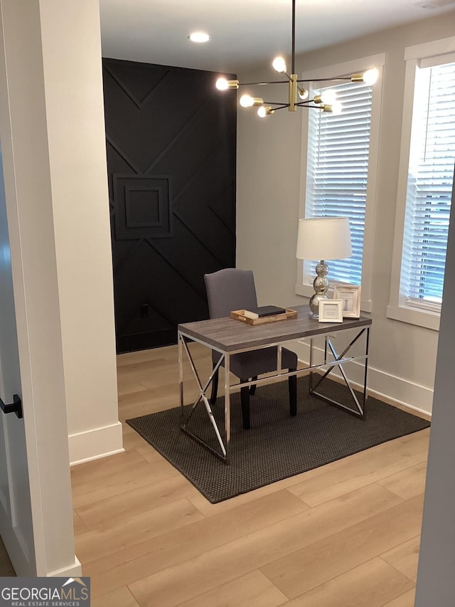 home office featuring wood-type flooring and a notable chandelier