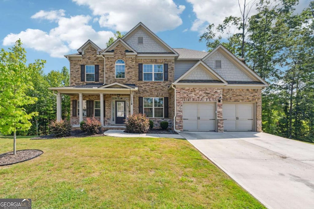 craftsman house with a front lawn, a porch, and a garage