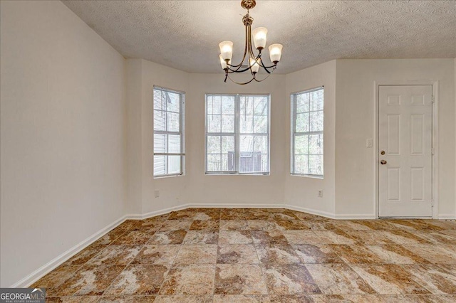 interior space with a textured ceiling and a chandelier