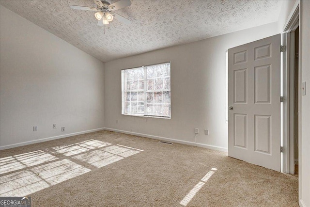 carpeted spare room featuring ceiling fan and a textured ceiling