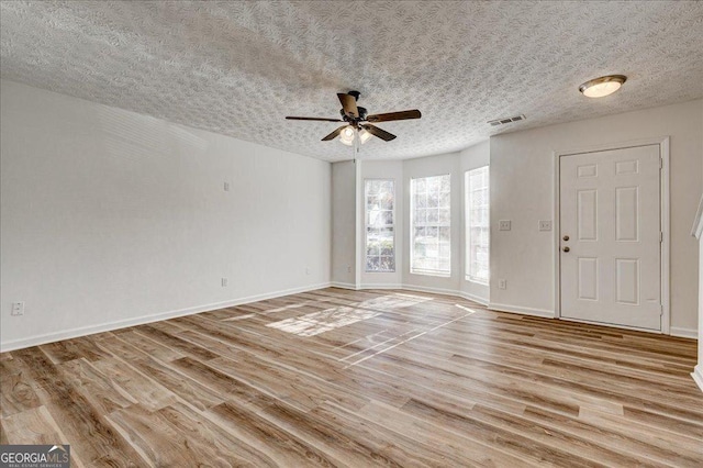 interior space featuring a textured ceiling, light hardwood / wood-style floors, and ceiling fan