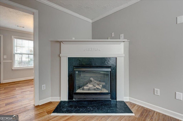 details featuring hardwood / wood-style floors, crown molding, and a textured ceiling