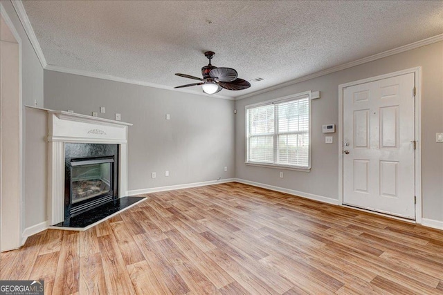 unfurnished living room with a textured ceiling, light wood-type flooring, ceiling fan, and crown molding