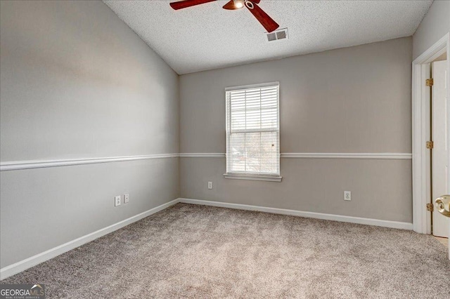 empty room featuring a textured ceiling, light colored carpet, ceiling fan, and lofted ceiling