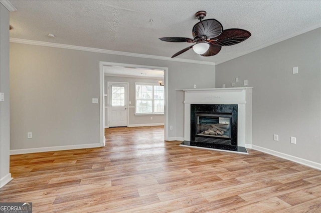 unfurnished living room featuring a fireplace, a textured ceiling, light hardwood / wood-style floors, and crown molding