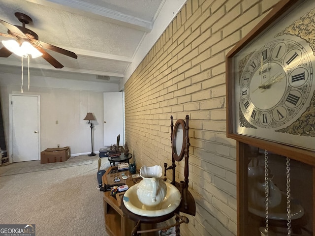 sitting room featuring carpet flooring, a textured ceiling, ceiling fan, and brick wall