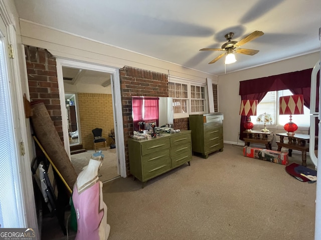 bedroom featuring ceiling fan, light colored carpet, and brick wall