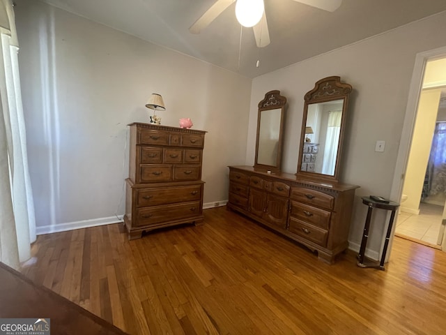 bedroom featuring connected bathroom, light hardwood / wood-style flooring, and ceiling fan