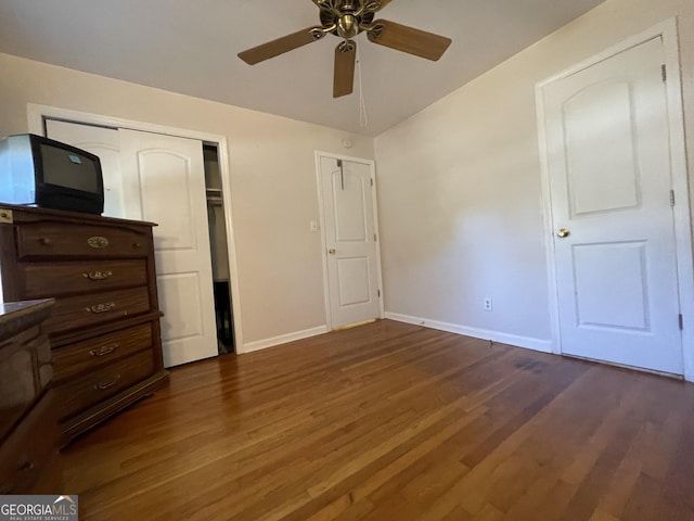 unfurnished bedroom featuring ceiling fan and dark wood-type flooring