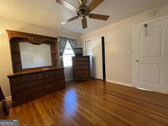 unfurnished bedroom featuring ceiling fan and dark hardwood / wood-style flooring