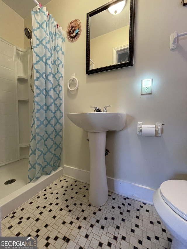 bathroom featuring a shower with shower curtain and toilet