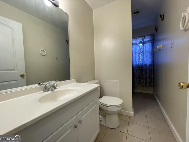 bathroom featuring tile patterned flooring, vanity, and toilet