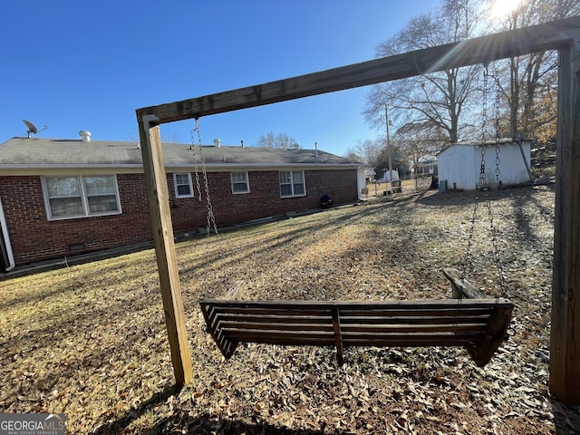 back of house with a lawn and a storage unit