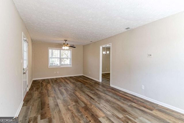 spare room featuring ceiling fan, dark wood-type flooring, and a textured ceiling