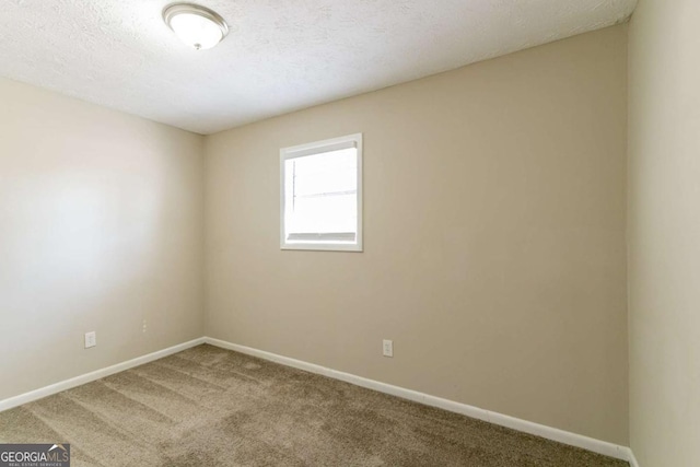 carpeted spare room with a textured ceiling