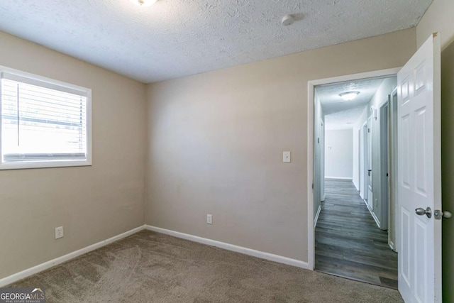 carpeted spare room featuring a textured ceiling