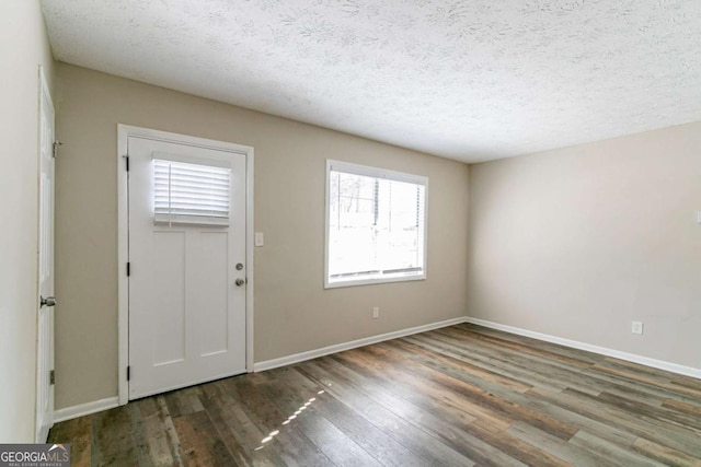 entrance foyer with a textured ceiling and dark wood-type flooring