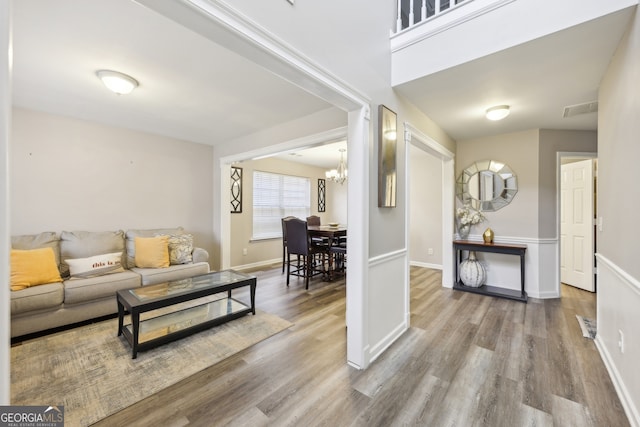 living room with wood-type flooring and a notable chandelier