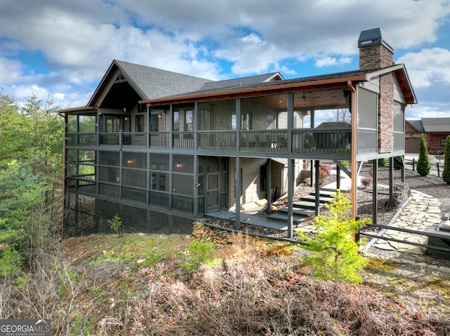 back of property with a sunroom