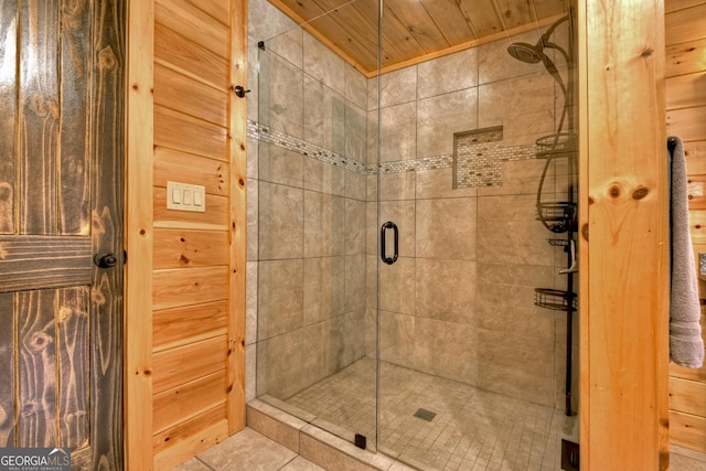 bathroom with tile patterned flooring, wood ceiling, and walk in shower