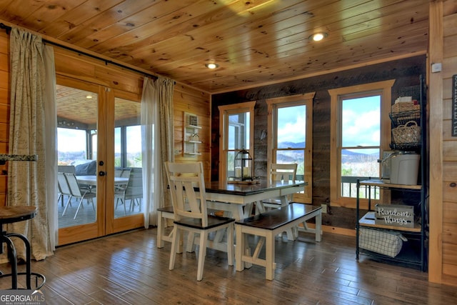 dining room featuring wood walls, dark hardwood / wood-style flooring, wooden ceiling, and french doors