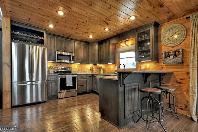 kitchen featuring light stone counters, wooden ceiling, stainless steel appliances, and dark wood-type flooring