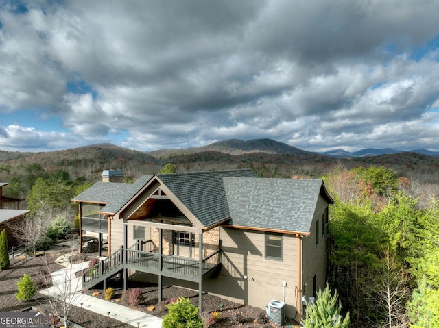 rear view of property featuring a deck with mountain view