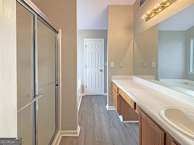 bathroom featuring hardwood / wood-style floors, vanity, and independent shower and bath