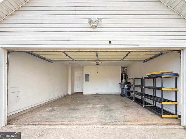 garage featuring electric panel and water heater