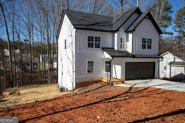 modern farmhouse style home featuring board and batten siding, driveway, an attached garage, and central air condition unit