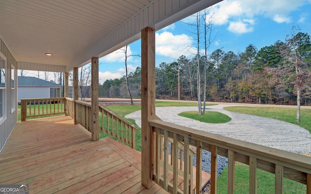 wooden terrace featuring a lawn