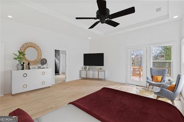 living room featuring a tray ceiling, hardwood / wood-style flooring, and ceiling fan