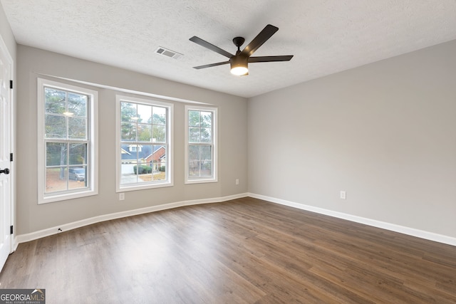 unfurnished room with ceiling fan, dark hardwood / wood-style flooring, and a textured ceiling