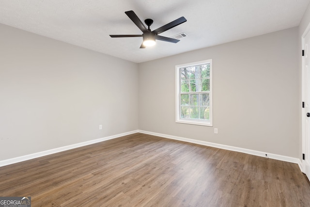 unfurnished room featuring hardwood / wood-style flooring, ceiling fan, and a textured ceiling