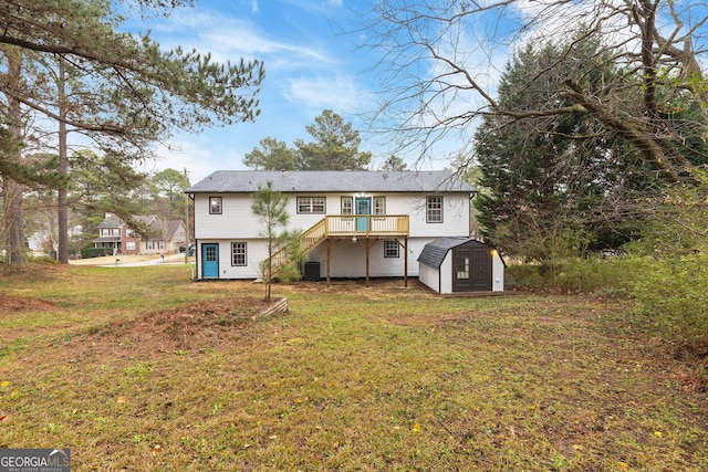 rear view of property featuring a yard, a deck, and a storage shed