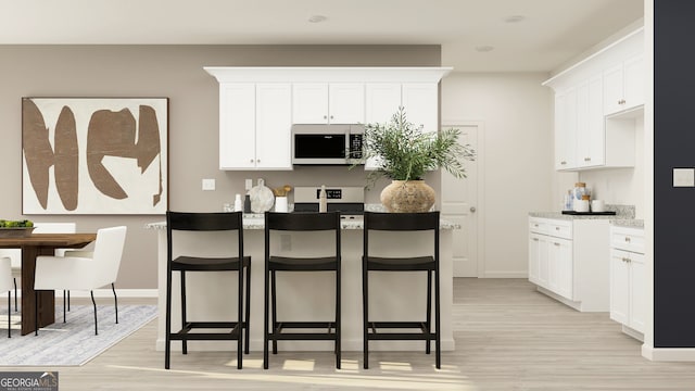 kitchen featuring white cabinets, stove, and light wood-type flooring