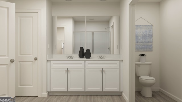 bathroom featuring hardwood / wood-style floors, vanity, toilet, and a shower with door