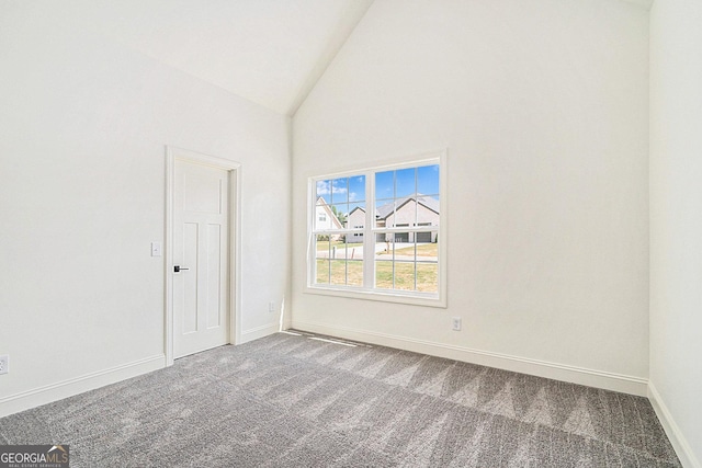 empty room with carpet and high vaulted ceiling